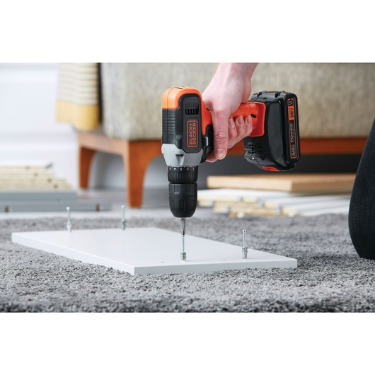Cordless Drill Driver being used to drive screws in rectangular slab.