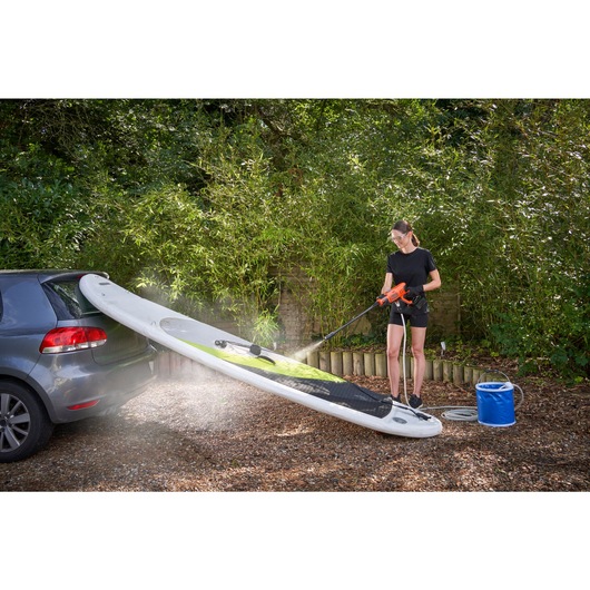 20 volt MAX cordless power cleaner kit being used by a person to wash a skateboard.