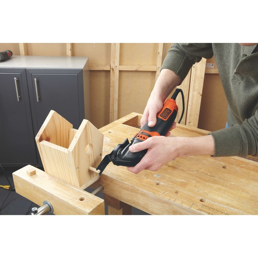 2.5 ampere oscillating multitool being used by a person.