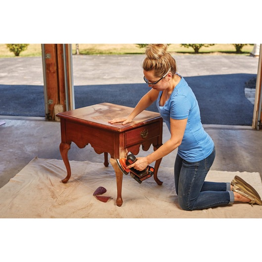 Mouse Detail Sander of Lithiuim Ion 4 Tool Combo Kit being used by person on wooden furniture.