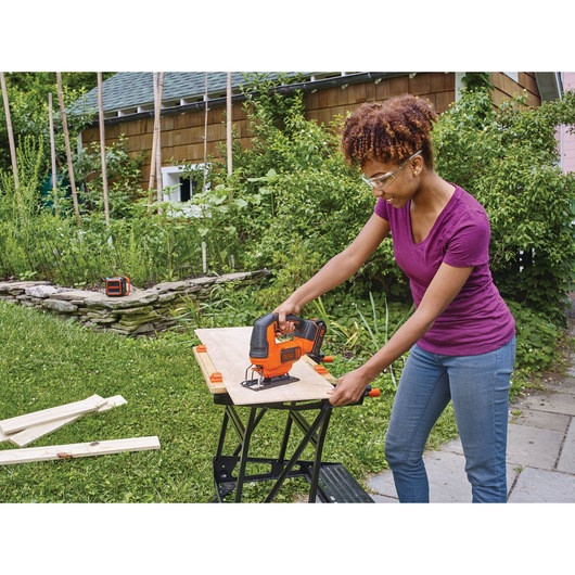 Cordless Jigsaw being used by person to cut wood.