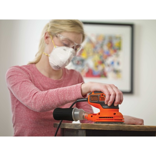 5 inch Random Orbital Sander being used by person to sand wood.