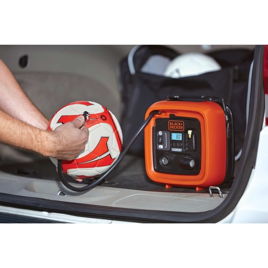12 volt d c multi purpose inflator being used to inflate a football.