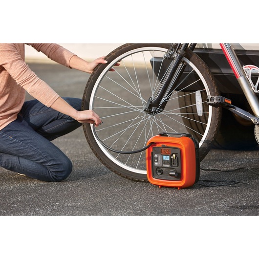 12 volt D C multi purpose inflator being used to inflate bicycle tire.