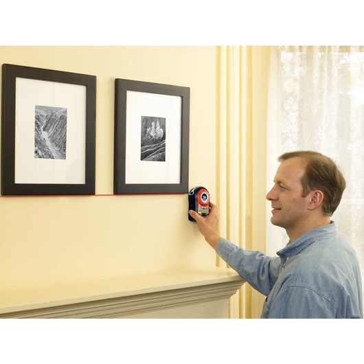 Bulls Eye Auto Leveling Laser with Angle Pro being used for hanging photo frames on wall.