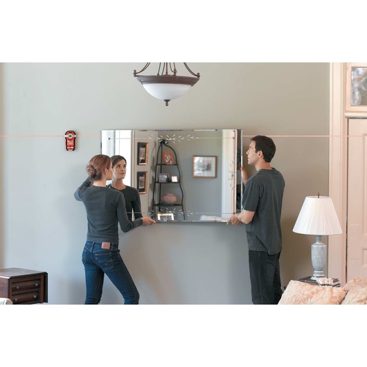 Bulls Eye Auto Leveling Laser with Stud Sensor being used for hanging mirror on wall.