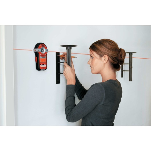 Bulls Eye Auto Leveling Laser with Angle Pro being used for hanging candle holder on wall.