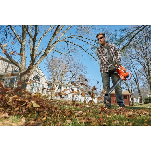 3 in 1 VACPACK 12 Amp Leaf Blower Vacuum and Mulcher being used to blow leaves by a person.