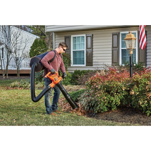 3 in 1 vacpack 12 amp leaf blower vacuum and mulcher being used by a person to vac debris.