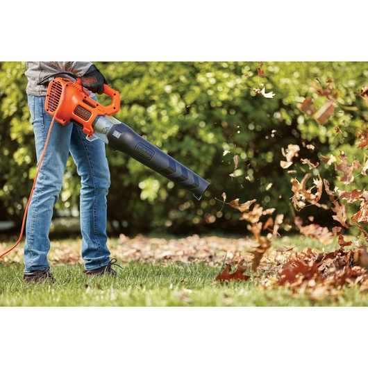 Electric axial leaf blower clearing debris.
