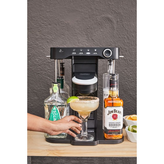 close-up, on the patio, of a woman's hand grabbing her margarita from the bev by BLACK+DECKER™ cocktail maker