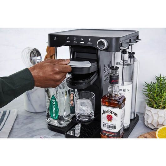 close-up, in the kitchen,  of a man's hand opening the capsule holder on the bev by BLACK+DECKER™ cocktail maker