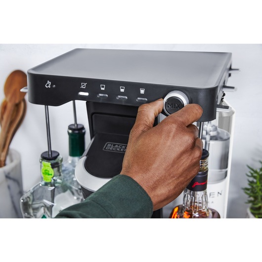 close-up, in the kitchen, of a man's hand adjusting the drink strength selecter knob to mocktail on the bev by BLACK+DECKER™ cocktail maker