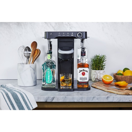 bev by BLACK+DECKER™ cocktail maker on a marble kitchen counter with a freshly made old fashioned admist kitchen utensils and décor