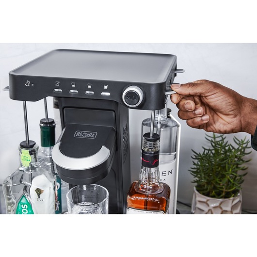 close-up, on the patio, of a man locking a bottle of whiskey into the easy load liquor system on the bev by BLACK+DECKER™ cocktail maker