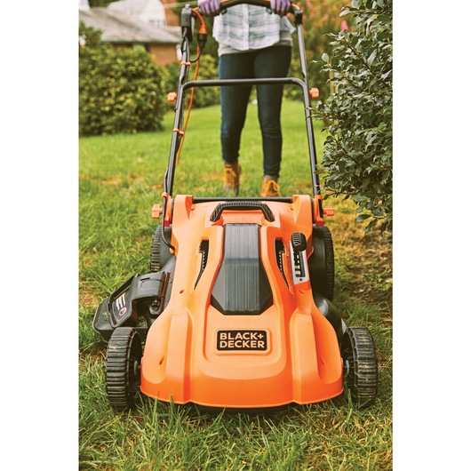 13 ampere 20 inch corded electric lawn mower being used to mow lawn.