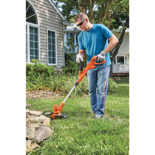 6.5 Ampere 14 inch AFS electric string trimmer edger being used by a person to edge grass.