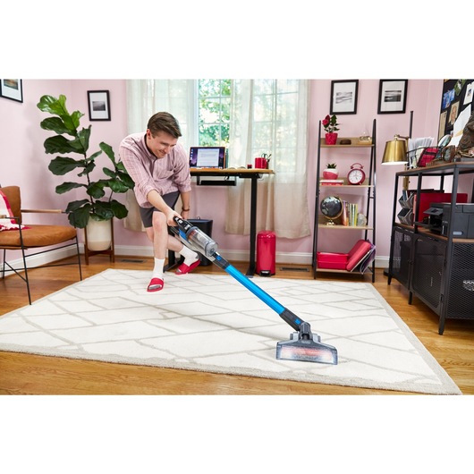 man dancing while cleaning with BLACK+DECKER PowerseriesExtreme stick vacuum