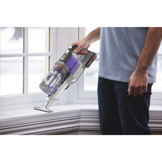 POWERSERIES Extreme pet cordless stick vacuum cleaner being used by a person to clean debris.