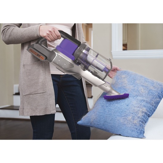 POWERSERIES Extreme Pet Cordless Stick Vacuum Cleaner being used by person to remove pet hair from cushion.
