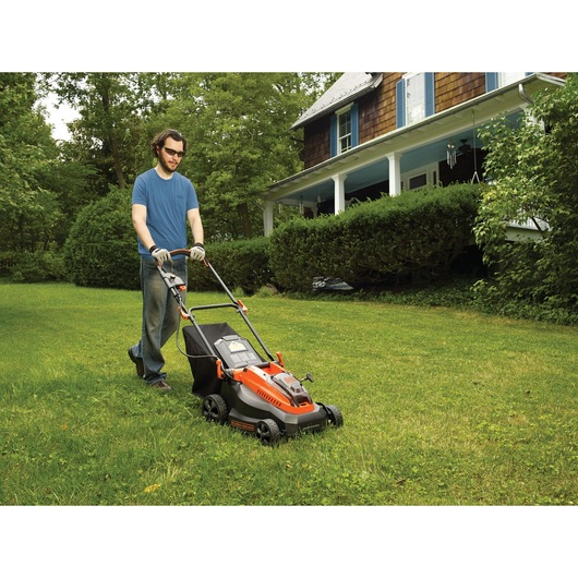 40 volt MAX lithium 16 inch mower being used by a person to mow grass.