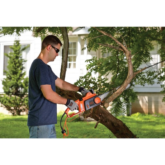 12 ampere 16 inch chainsaw being used by a person.