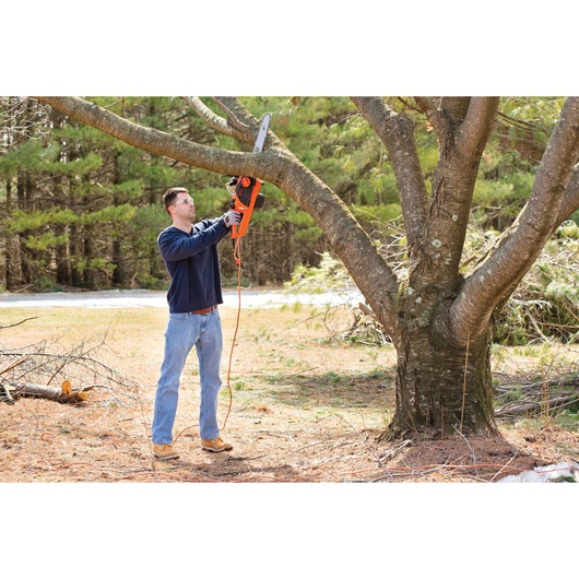 Chainsaw being used by a person to cut tree.
