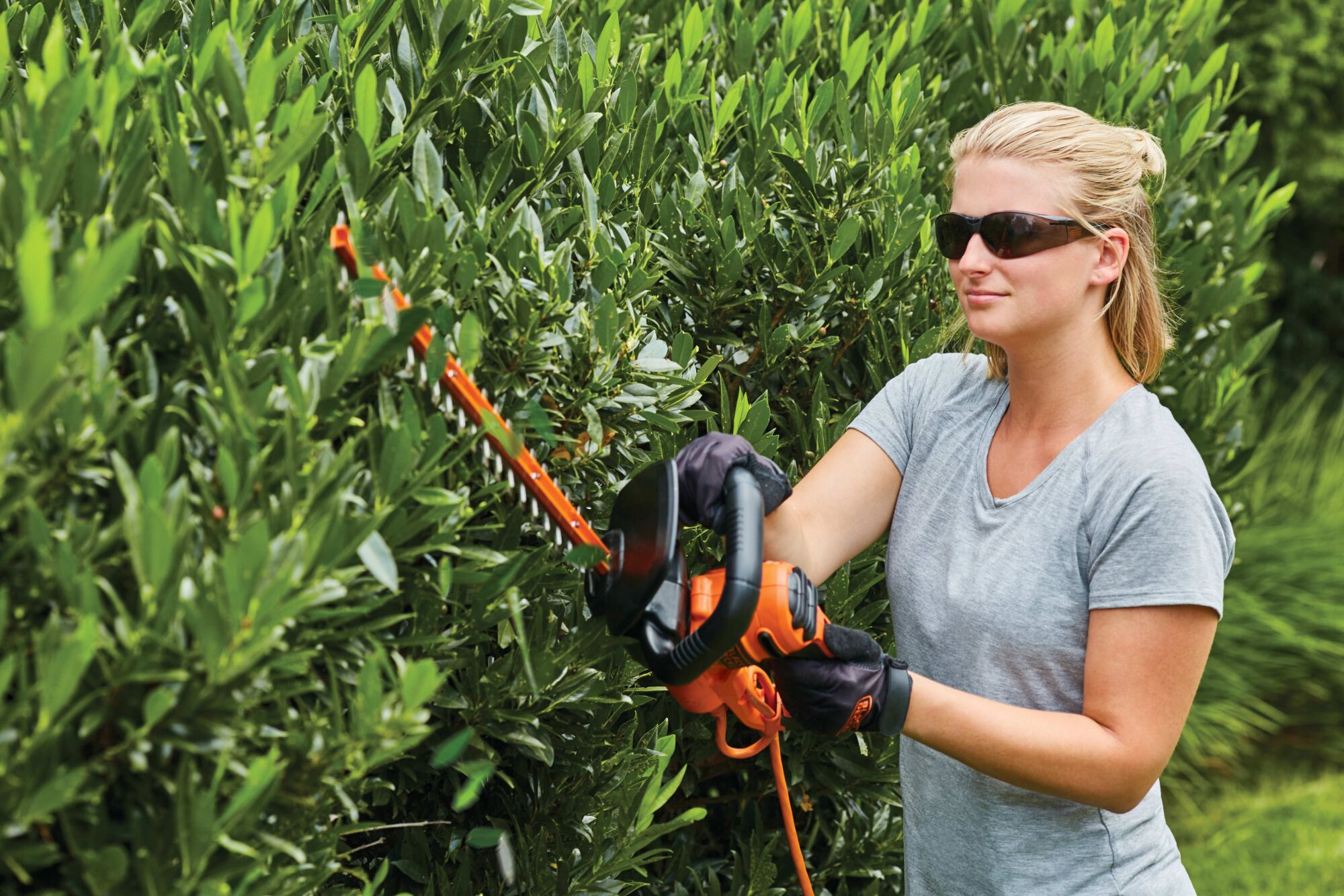 18 inch Electric Hedge Trimmer being used by person to trim hedge outdoors.