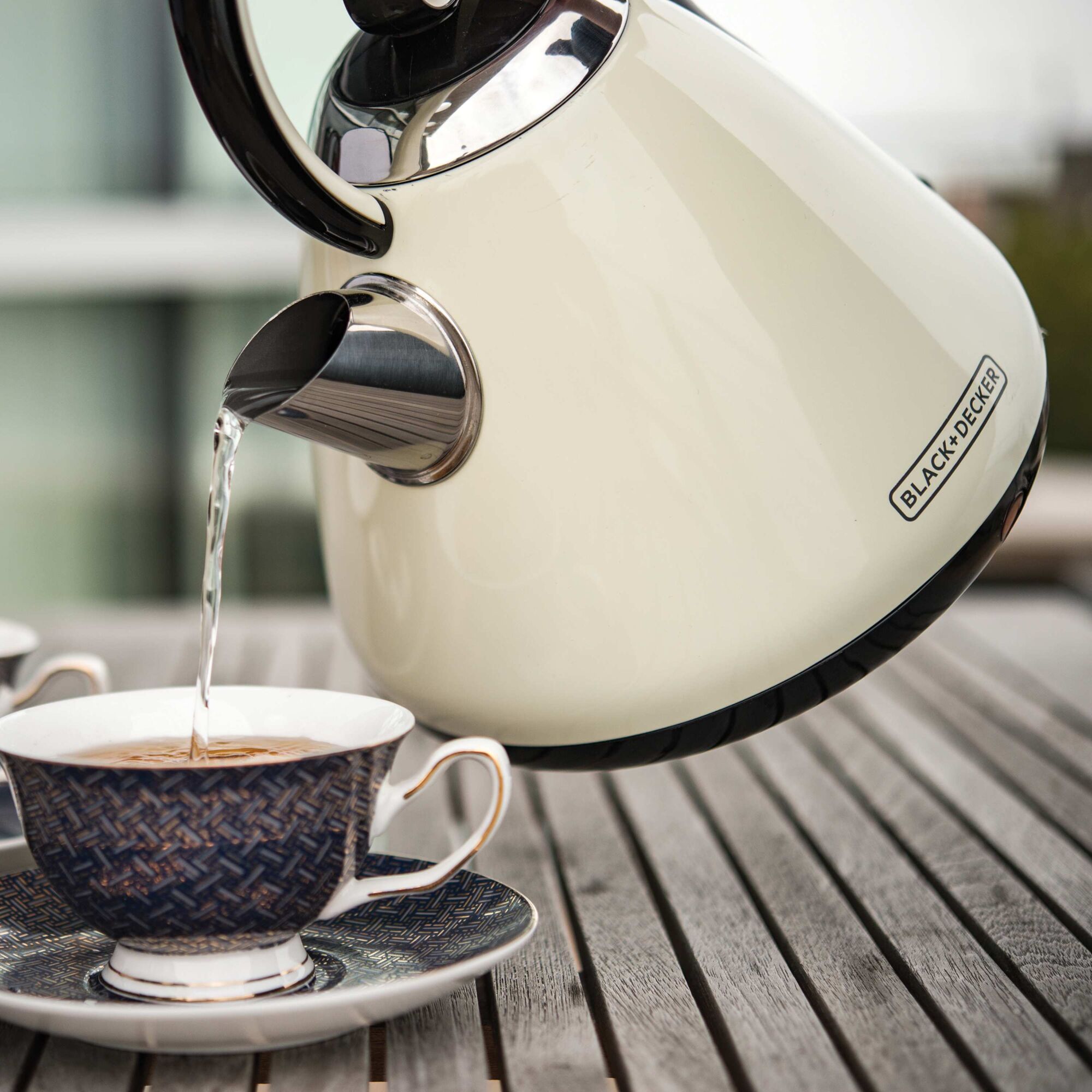 1.7 liter Stainless Steel Electric Cordless Kettle being used to pour hot water into cup.