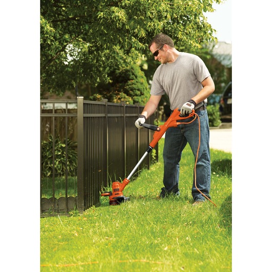 Trimmer / edger being used by a person to trim grass.

