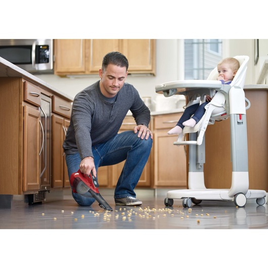 dustbuster Advanced Clean cordless hand vacuum being used to clean food spillage on kitchen floor.