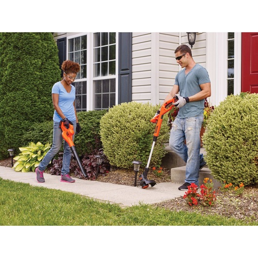 2 lithium 10 inch string trimmer and edger being used by two people in the outdoors.