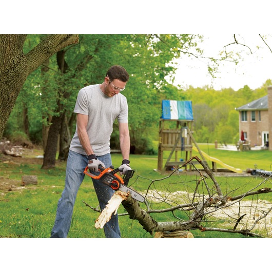 Lithium 10 inch Chainsaw being used to cut tree branch.