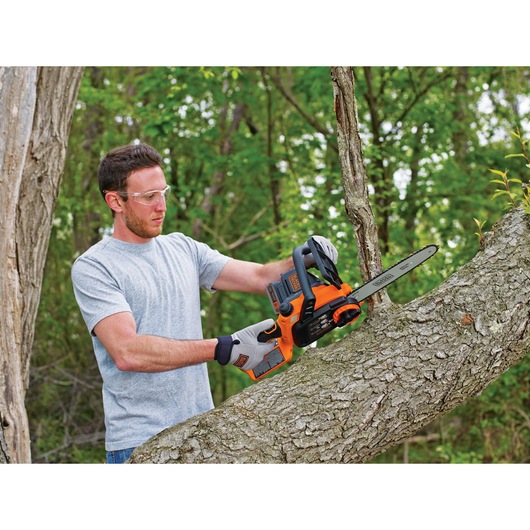 20 Volt Lithium 10 inch Chainsaw being used by a person on a tree branch.