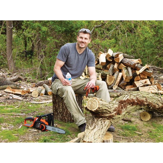 A person satisfied cutting branches of tree using Lithium 12 inch chainsaw.
