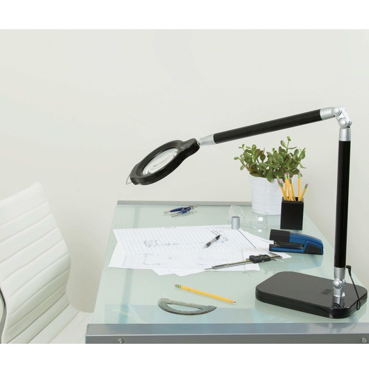 Ultra reach magnifier L E D desk lamp black placed on writing table.
