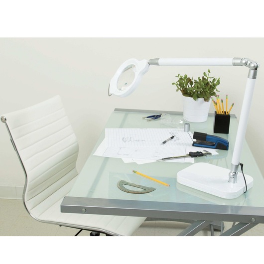 Ultra reach magnifier L E D desk lamp on study table with stationery items.