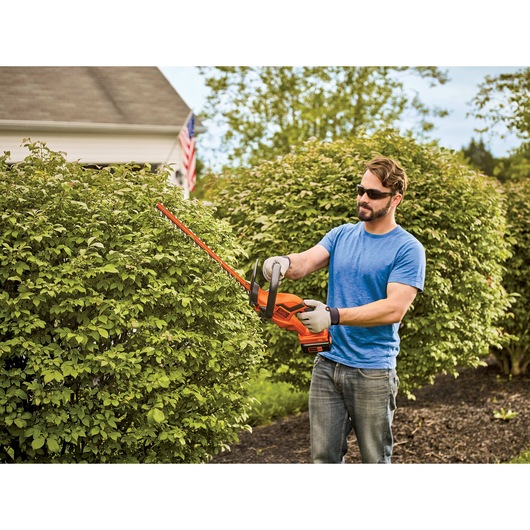 40 volt 22 inch hedge trimmer being used by a person.