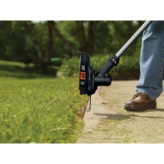 40 volt MAX Cordless String Trimmer with POWERCOMMAND being used on the ground outdoors.