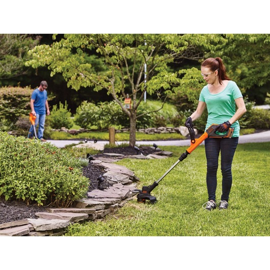 20 volt lithium 12 inch 2 speed string trimmer or edger being used by a person.
