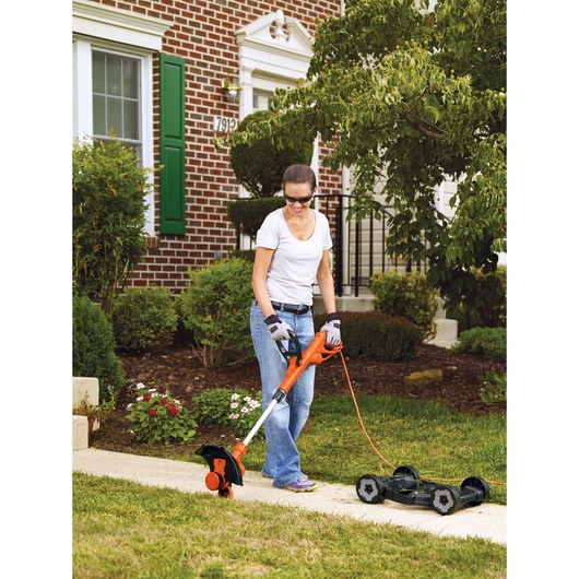 Electric 3 in 1 Compact Mower being used for trimming garden edges.